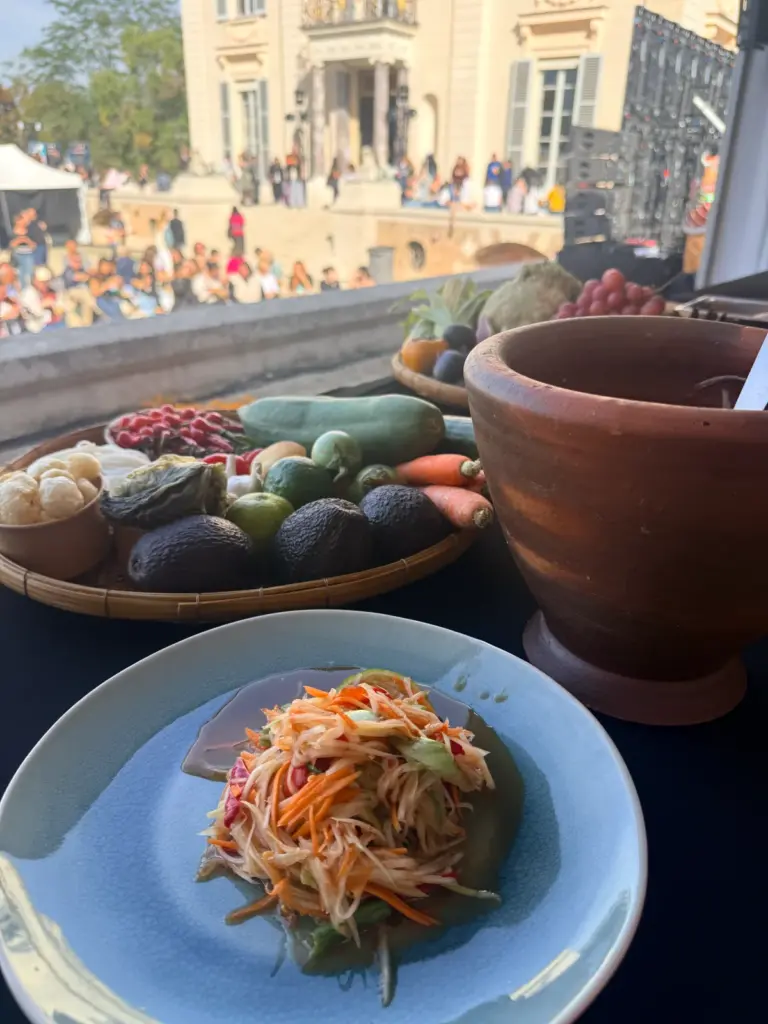 Ingrédients frais, légumes, mortier en terre cuite et salade de papaye verte disposés pour une préparation culinaire thaïlandaise.