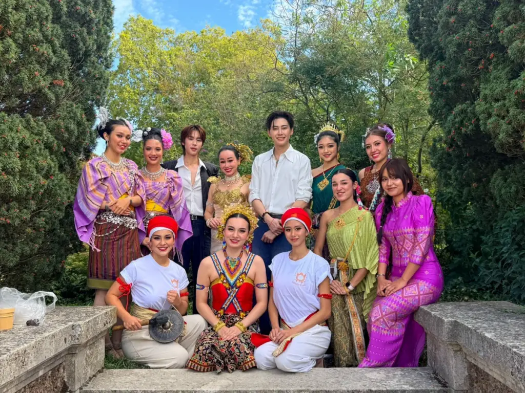 Groupe de participants et d'artistes en tenues traditionnelles et contemporaines réunis pour une photo souvenir.