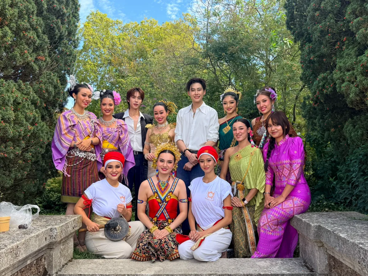 Groupe de participants et d'artistes en tenues traditionnelles et contemporaines réunis pour une photo souvenir.